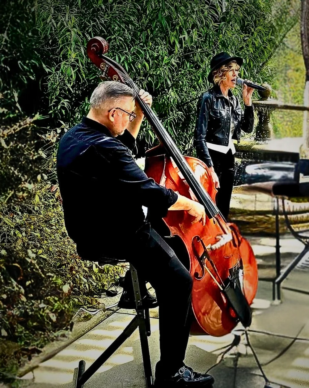 Denise Choate singing outdoors beside John Ady on upright bass